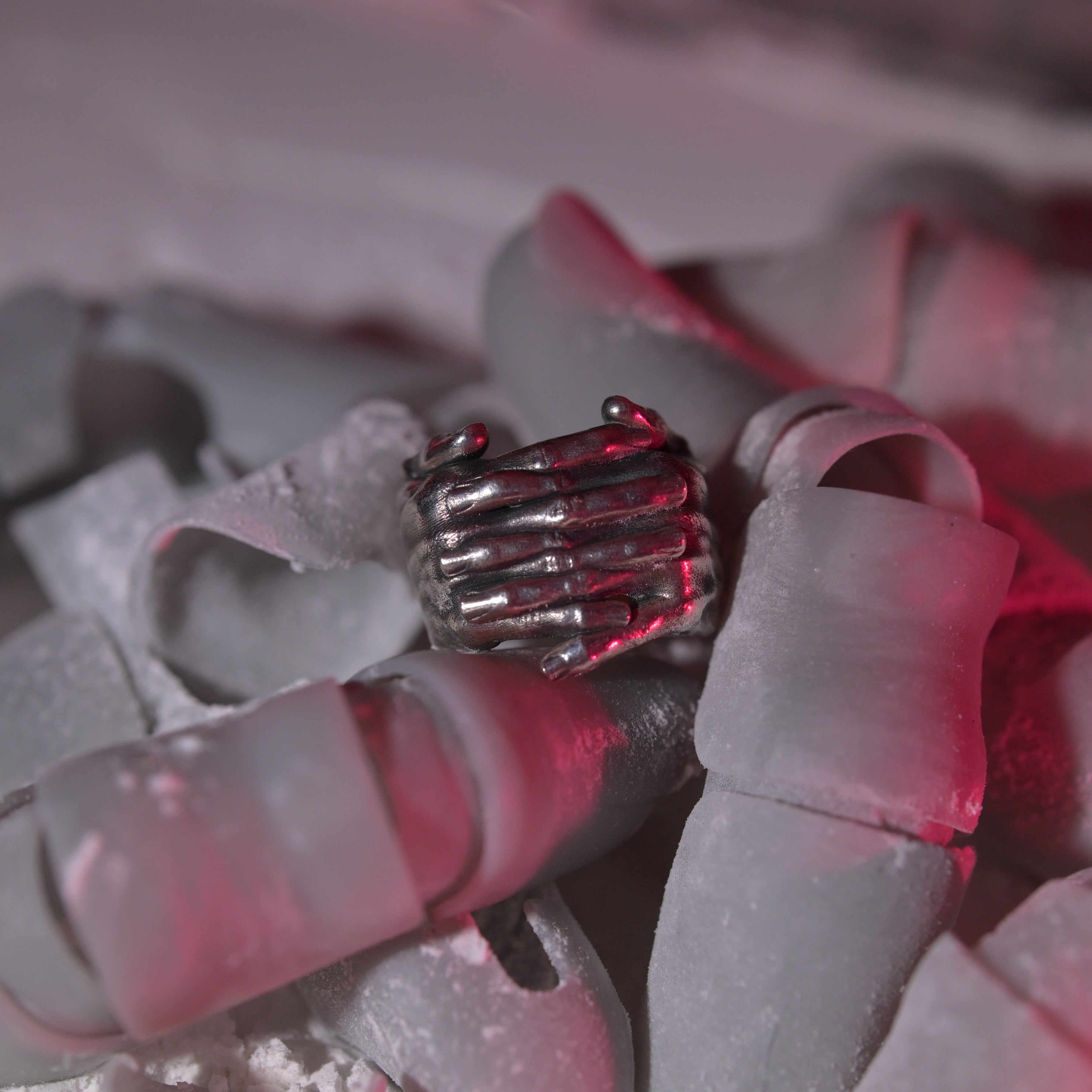 MTHR Interlace Ring close up on a pile of plastic fingers covered in dust