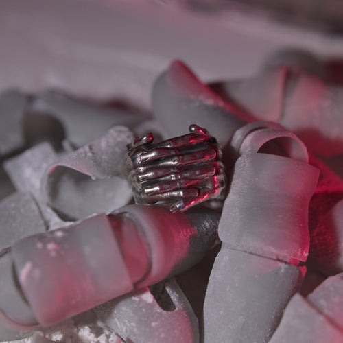 MTHR Interlace Ring close up on a pile of plastic fingers covered in dust
