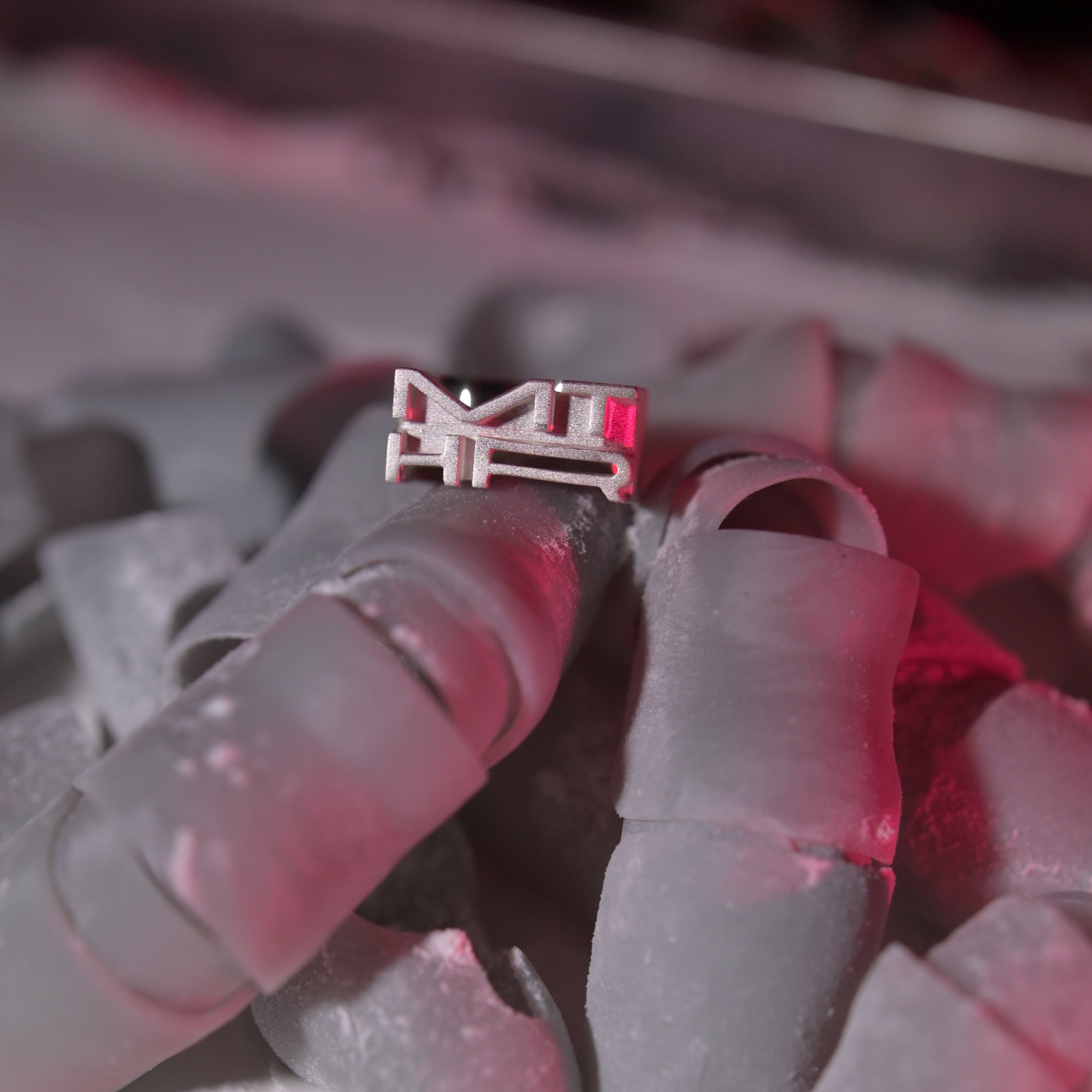 Close up of logo ring in a pile of plastic fingers covered in dust