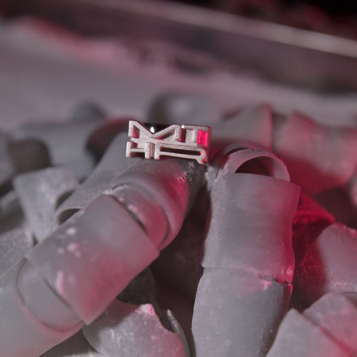 Close up of logo ring in a pile of plastic fingers covered in dust